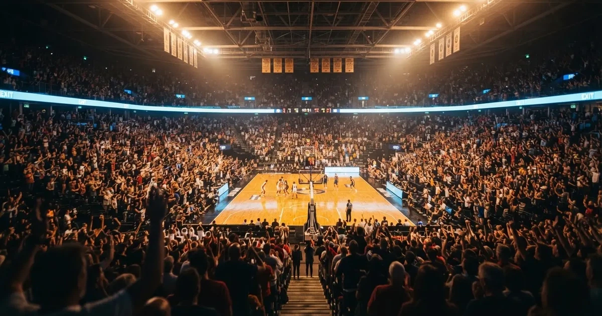 Un pabellón deportivo lleno bajo los focos, fotografiado desde muy lejos