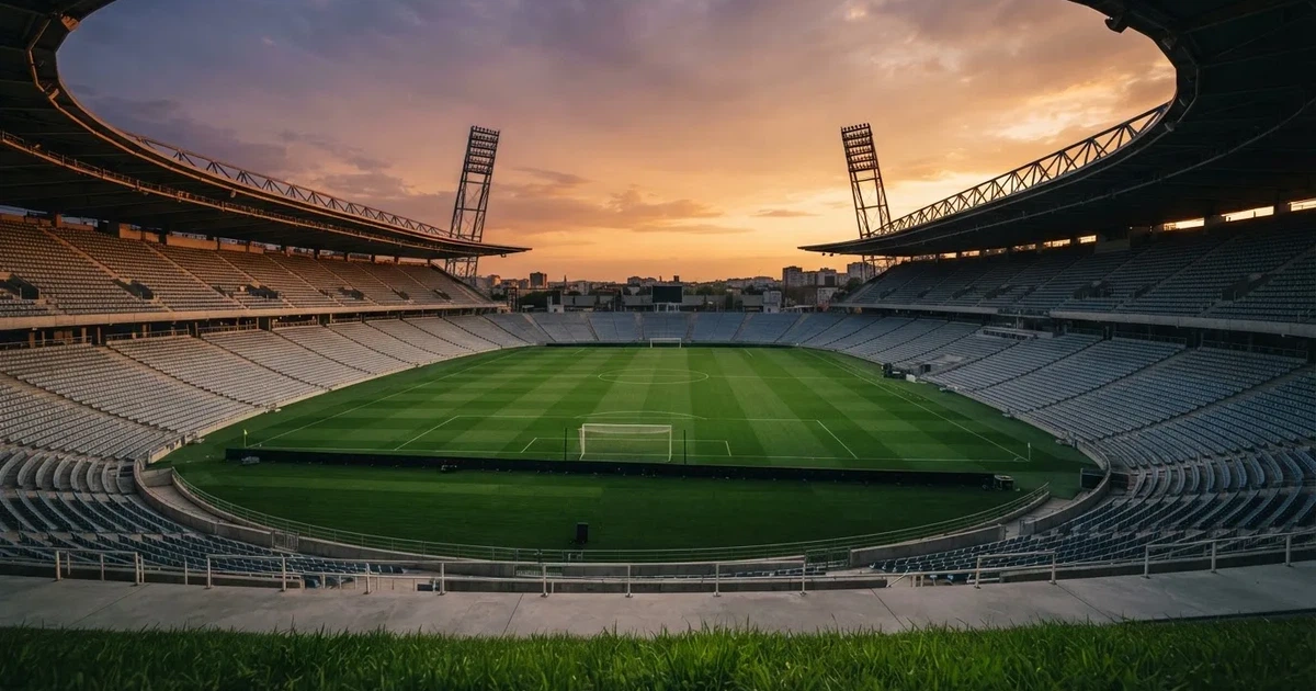Un estadio de fútbol vacío con torres de iluminación al atardecer